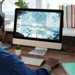 A person working on digital marketing at a well-organized workspace with a computer.